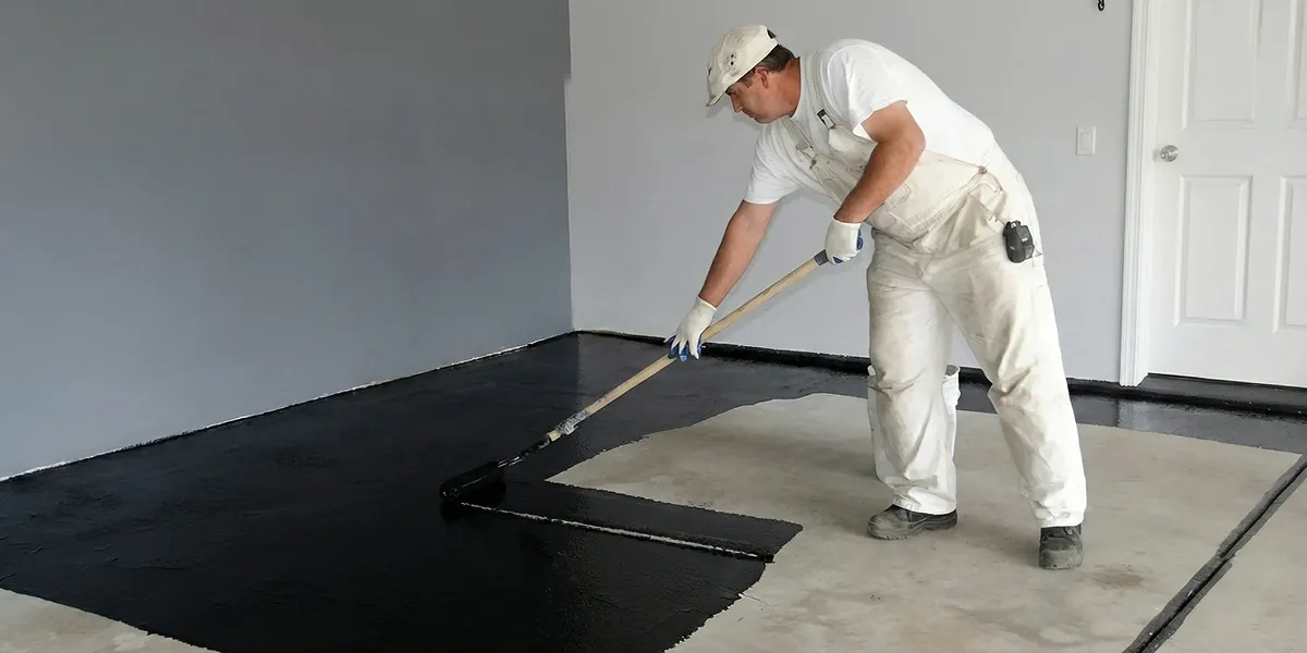 basement waterproofing professional applying waterproof coating to protect a basement floor in Nashville, TN
