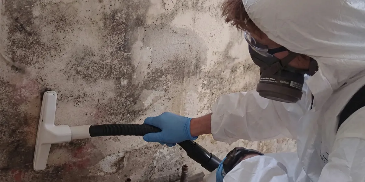 professional mold removal technician wearing protective equipment removing mold from a wall in Nashville, TN